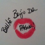 marca de boca pintada de batom rosa choque em folha de papel com mensagem :no centro da marca da boca "Benhê, beijo da pitchuca!"