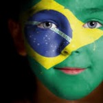 rosto de menino de 7 anos pintado com as cores da bandeira do brasil.