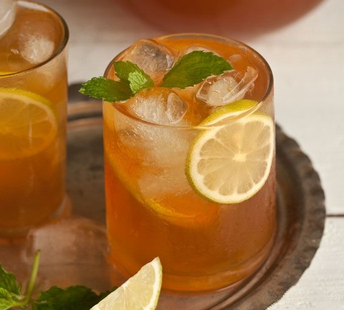 bandeja em prata, com 3 copos estilo drink, com chá gelado, decorados com rodelas de limão e folhas de hortelã nas bordas