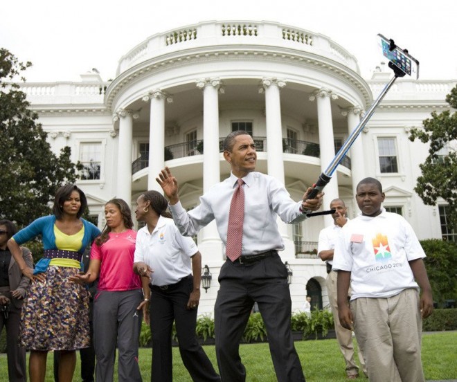 Presidente Barack Obama, dos Estados Unidos da América, está no jardim da Casa Branca, sede do Governo Americano, usando um "pau-de-selfie" para fazer uma foto de todos. Junto a ele Michelle Obama e algumas pessoas.