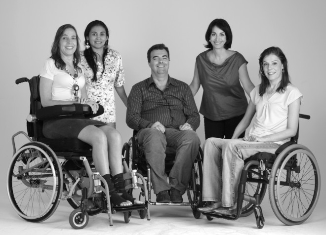 Claudia Matarazzo, de pé com as mãos apoiadas , Está entre a deputada Mara Gabriili e Flavia Cintra, ambas cadeirantes, imagem do livro Vai Encarar.