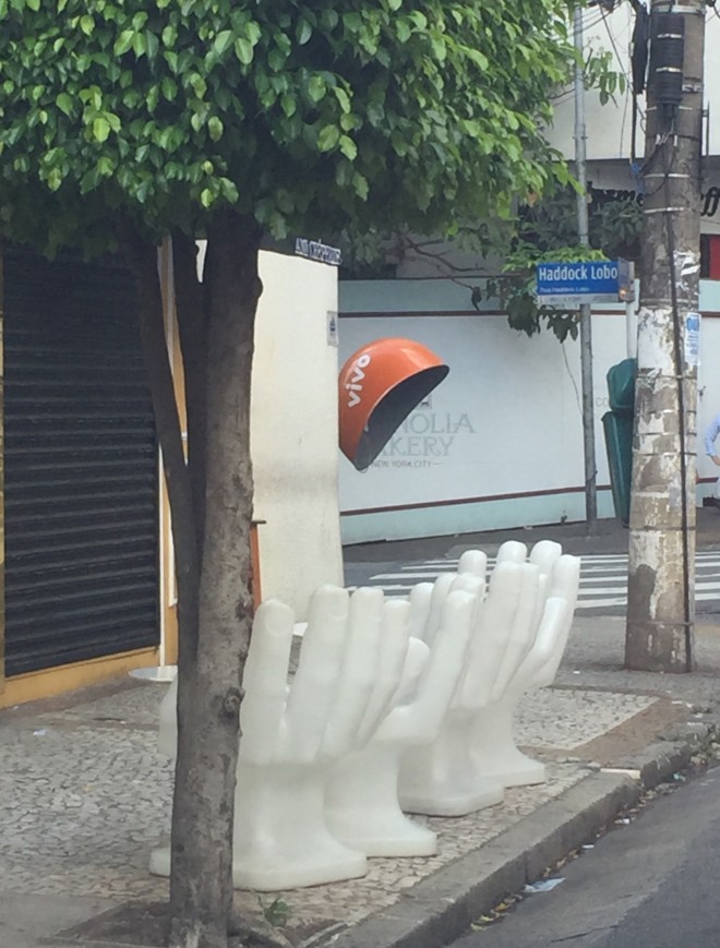 Objeto de decoração de rua - onde temos várias mesas onde os bancos e cadeiras estão em forma de mão