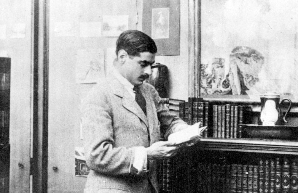 Imagem de namorado de Coco Chanel - Senhor Arthur Capel - usando terno claro junto a um móvel com livros.