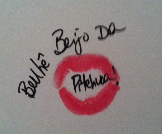 marca de boca pintada de batom rosa choque em folha de papel com mensagem :no centro da marca da boca "Benhê, beijo da pitchuca!"
