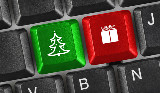 a imagem mostra parte de um teclado de computador sendo que uma tecla foi substituída por um pinheiro de natal e a outra por um presente. Uma tecla verde e outra vermelha.
