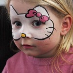 menina pintada com a mascara da gatinha Hello Kitty.